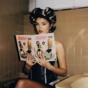 Ruby Roberts holding a magazine with rollers in her hair